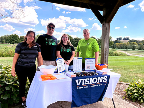 Visions staff and staff of Big Brothers Big Sisters of Berks County pose for a photo at the Visions FCU table