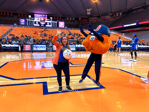 Sarah Parton, Business Development Officer and Otto the Orange having fun on the Syracuse University Basketball Court
